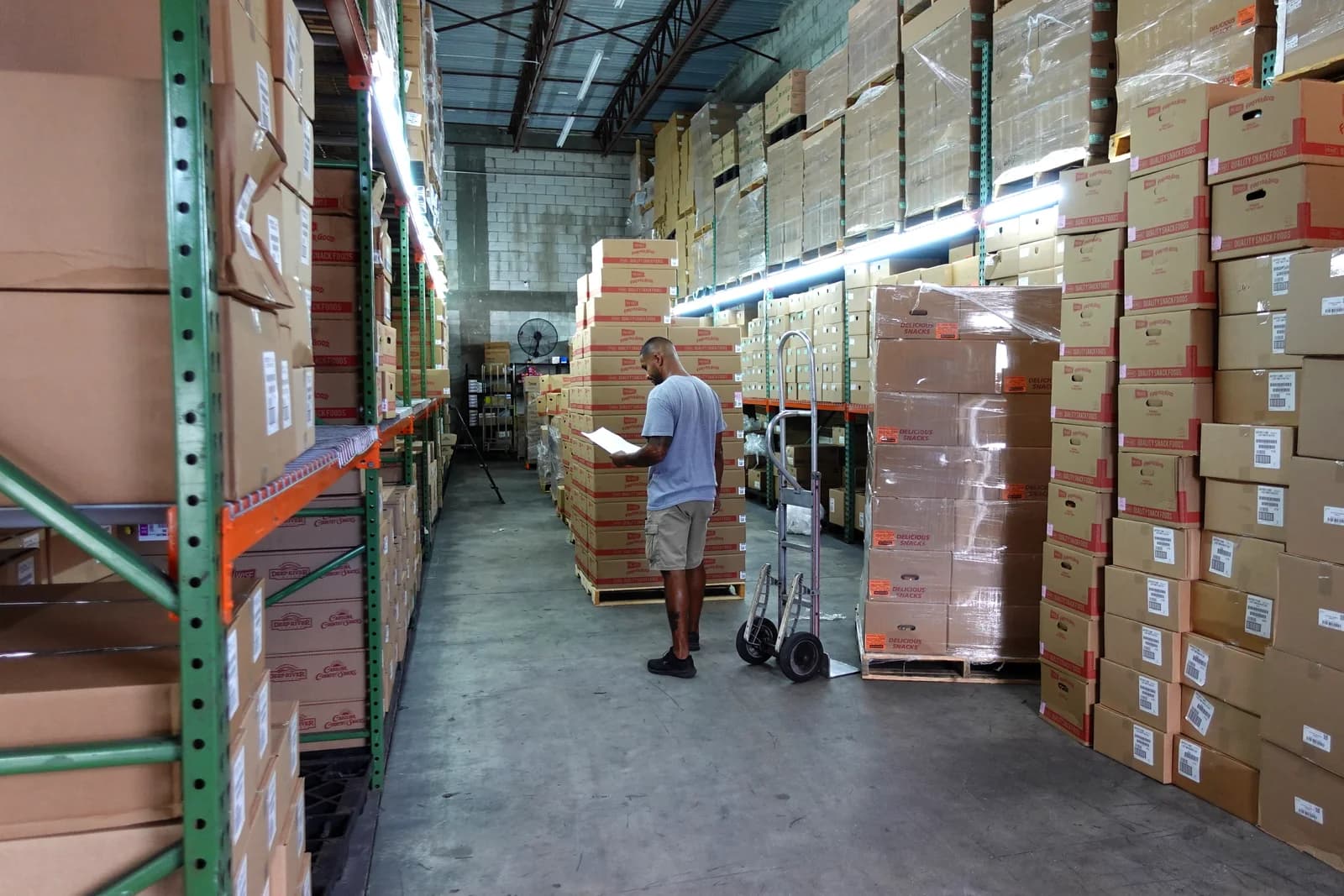 A Riega Snacks team member checking an order sheet in the Coconut Creek warehouse